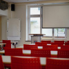 Flipchart und Leinwand mit Seminarbestuhlung