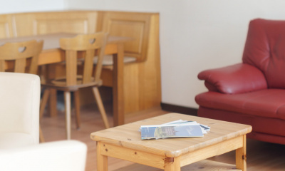 Wohnzimmer mit TV, gemütlichem Sofa und Sesseln