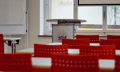 Seminarraum 5 mit Tischen, Rednerpult und Beamer