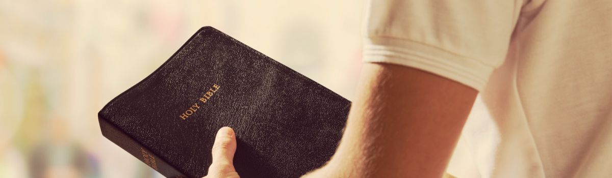 Bibel in der Hand eines Mannes