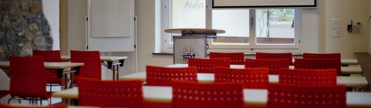 Seminarraum 5 mit Tischen, Rednerpult und Beamer